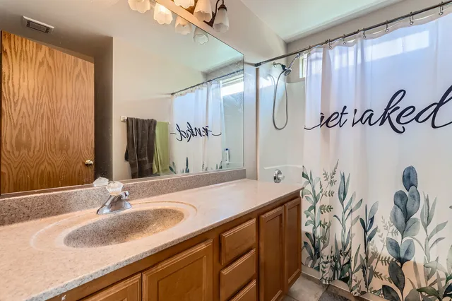 a bathroom with a granite countertop sink and a mirror