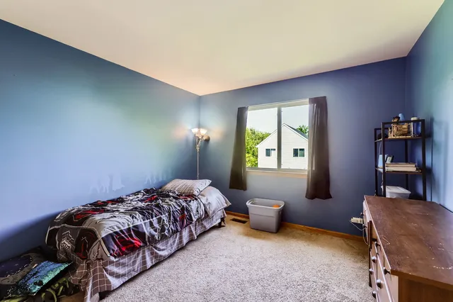 a bedroom with a bed and a chair