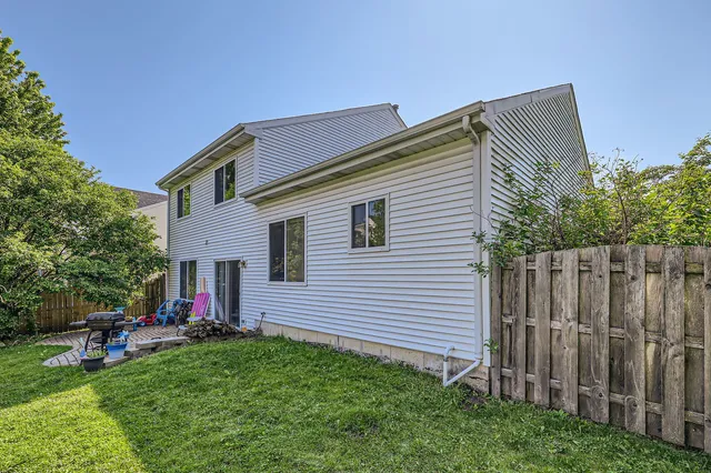 a backyard of a house with table and chairs
