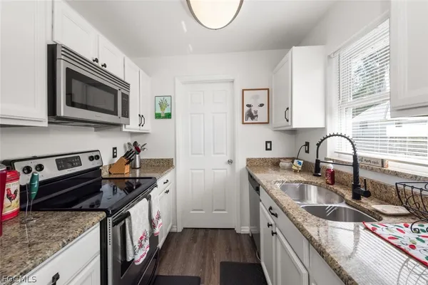 a kitchen with stainless steel appliances granite countertop a sink stove and cabinets