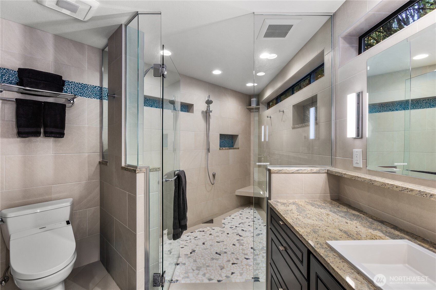 6520 East Mercer Way Mercer Island, WA 98040 - Photo 29 of 36 a bathroom with a granite countertop sink a large mirror a toilet and a shower