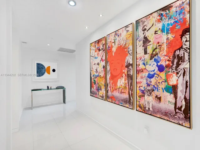 a room with painting on the wall and a window