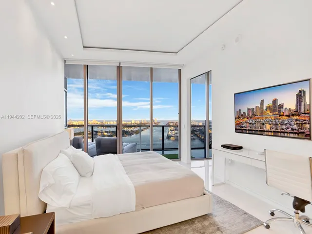 a bedroom with a large bed and a large window