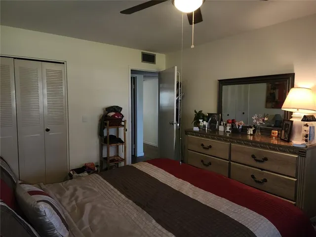 a bedroom with a bed and a mirror on dresser