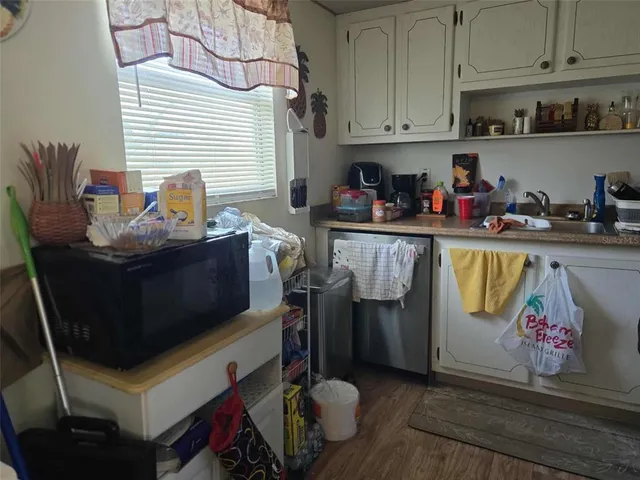 a room with stainless steel appliances kitchen island granite countertop a table and chairs in it