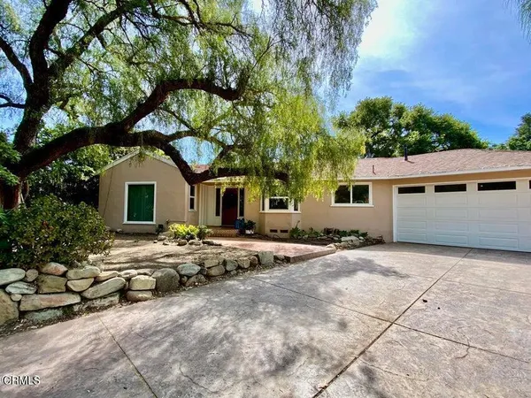 a view of a house with a tree and covered area