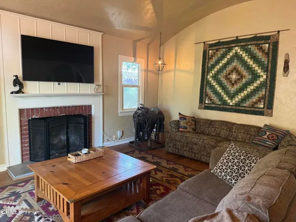a living room with furniture a flat screen tv and a fireplace