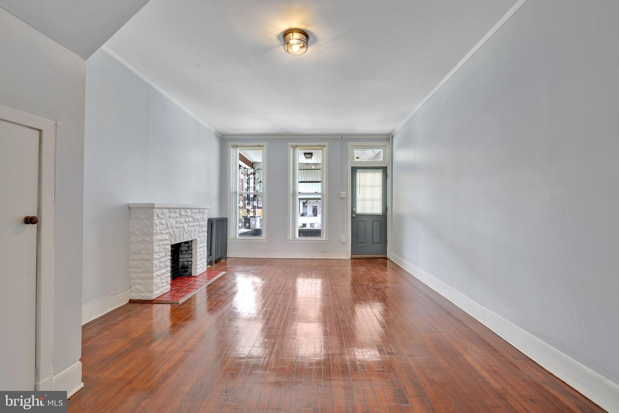 2822 Riggs Avenue Baltimore, MD 21216 - Photo 3 of 30 wooden floor fireplace and natural light in room