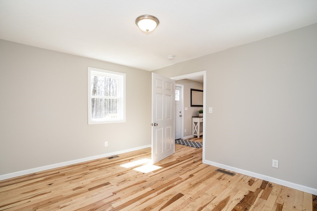 87 McBride Road Wales, MA 01081 - Photo 14 of 36 an empty room with wooden floor and windows