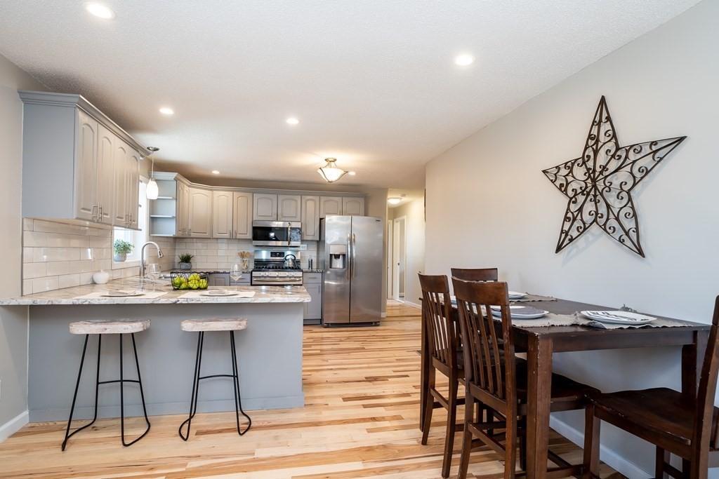 87 McBride Road Wales, MA 01081 - Photo 2 of 36 a kitchen with stainless steel appliances kitchen island granite countertop a dining table chairs and a refrigerator