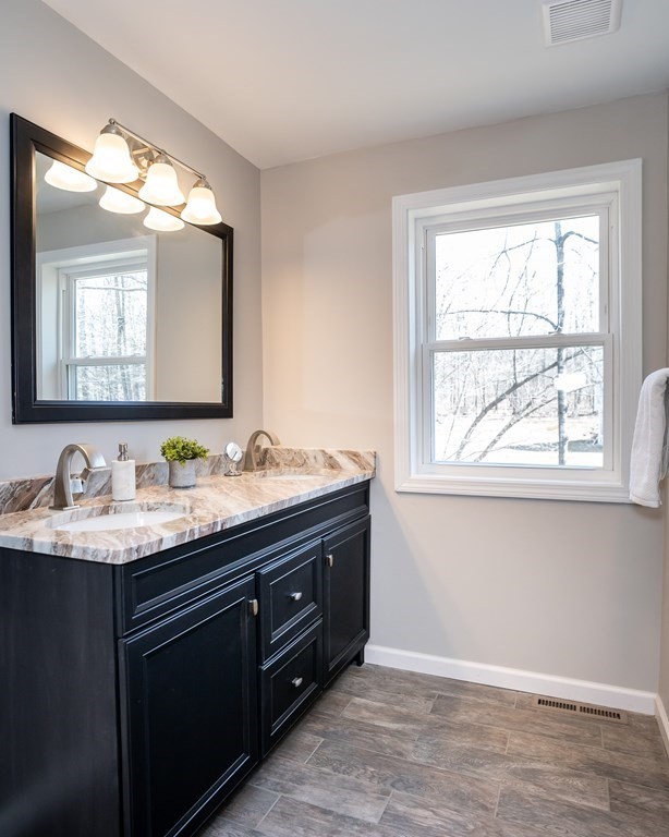 87 McBride Road Wales, MA 01081 - Photo 23 of 36 a bathroom with a granite countertop sink a large mirror a and window