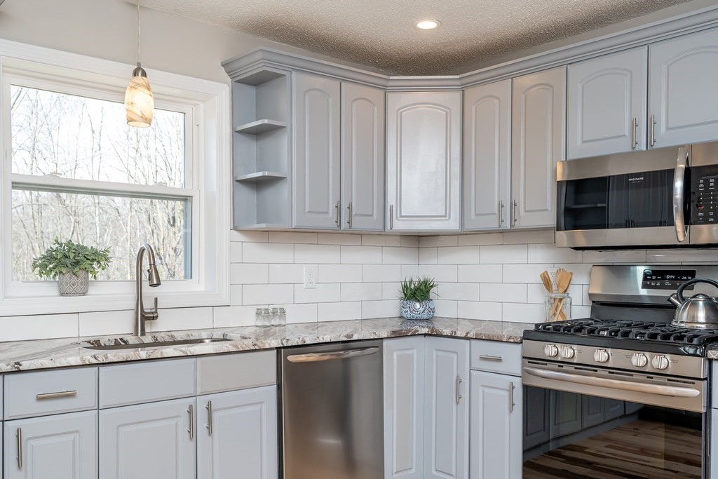 87 McBride Road Wales, MA 01081 - Photo 4 of 36 a kitchen with granite countertop white cabinets stainless steel appliances and a sink