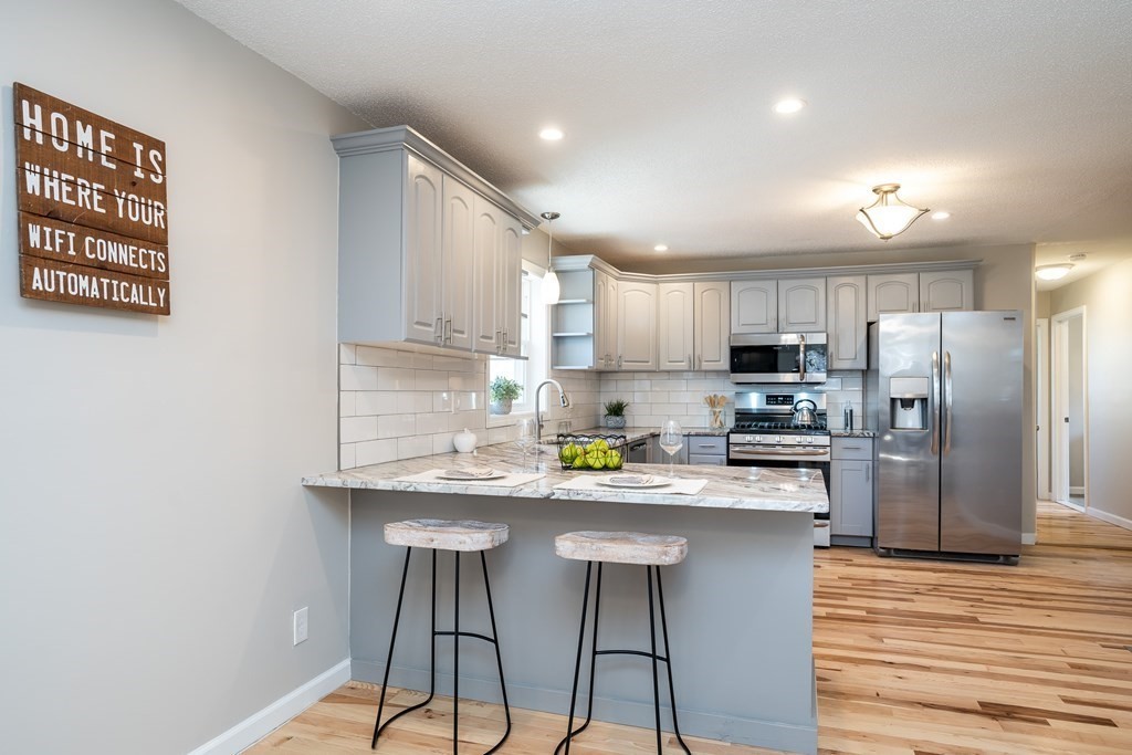87 McBride Road Wales, MA 01081 - Photo 6 of 36 a kitchen with stainless steel appliances granite countertop a sink a stove a refrigerator cabinets and wooden floor