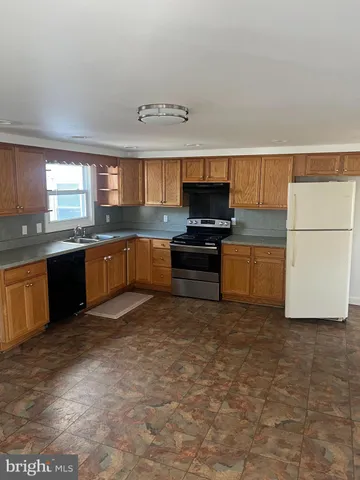 a large kitchen with stainless steel appliances granite countertop a sink and a stove