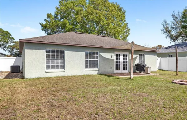 a view of a house with a yard and large tree