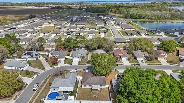 an aerial view of residential houses with outdoor space and lake view