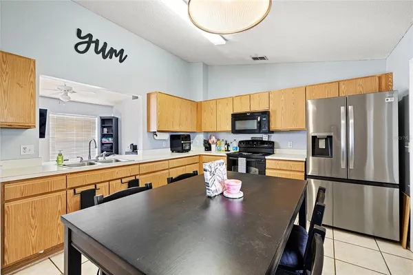 a kitchen with stainless steel appliances granite countertop a sink refrigerator stove microwave and cabinets