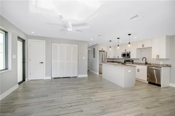 a large white kitchen with white cabinets