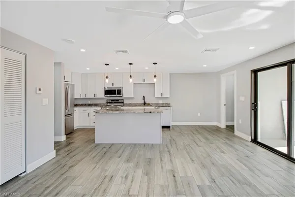 a kitchen with a refrigerator and white cabinets