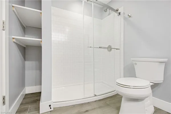 a bathroom with a toilet and a shower