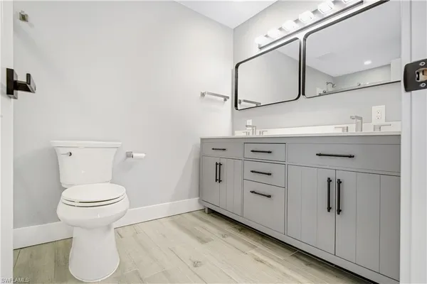 a bathroom with a sink a toilet and mirror