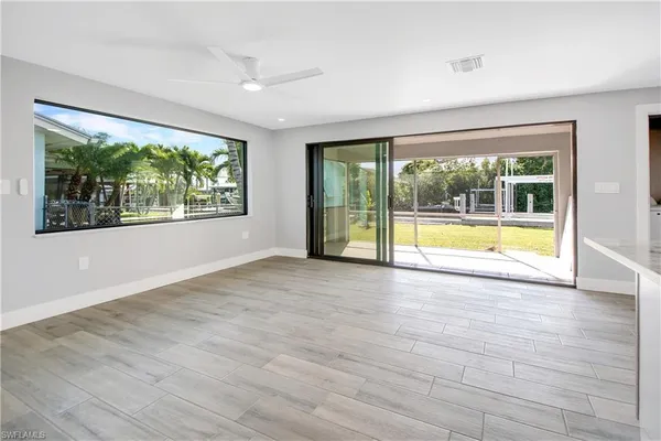 an empty room with wooden floor and outdoor view