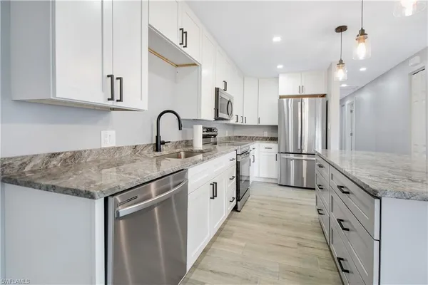 a large kitchen with granite countertop a sink and cabinets