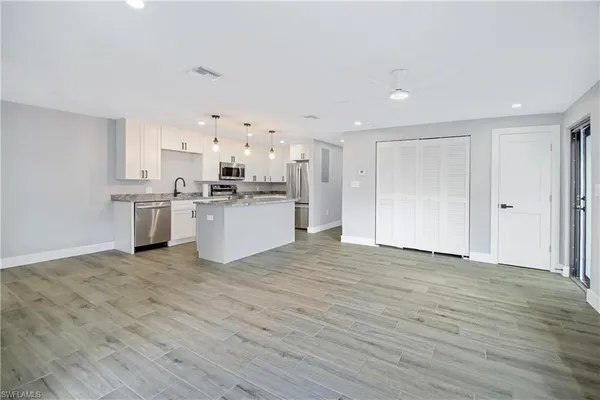 a view of a kitchen with a sink a refrigerator and window