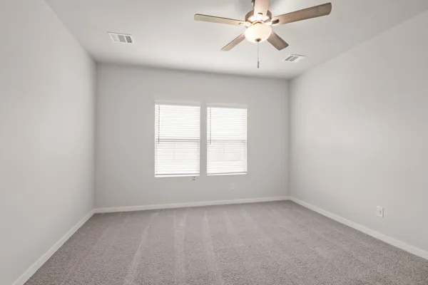 an empty room with a window and a fan