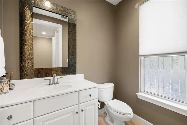 a bathroom with a sink vanity mirror and toilet