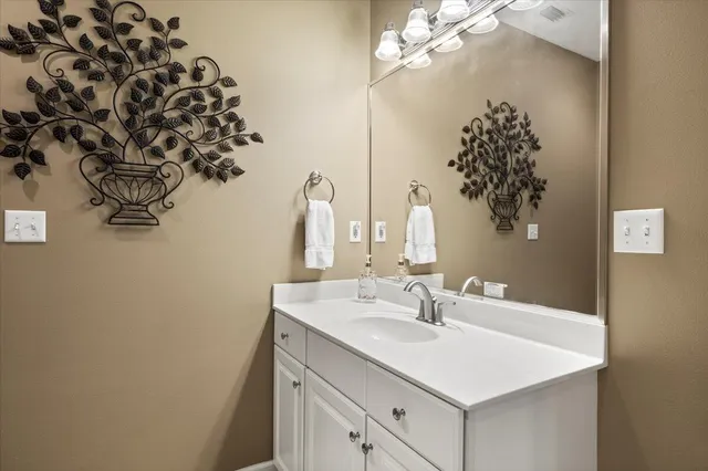 a bathroom with a sink vanity and a mirror