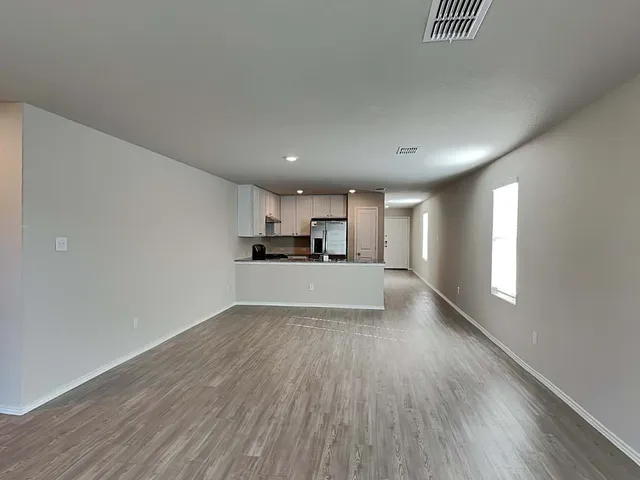 a kitchen with granite countertop kitchen island wooden cabinets a refrigerator stove top oven and sink