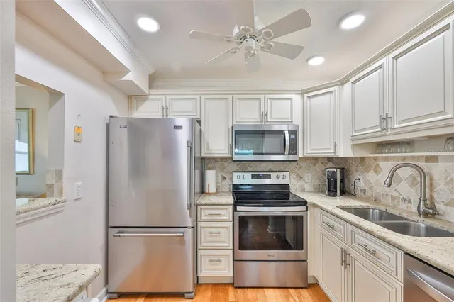 a kitchen with stainless steel appliances a refrigerator sink and cabinets