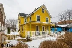 a view of a white house with large windows and a small yard