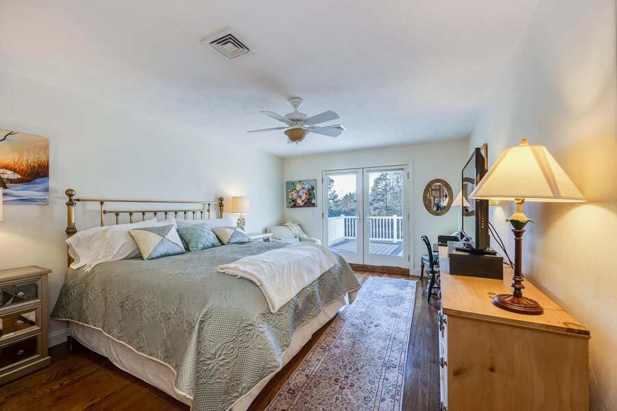 310 Willowbend Drive Mashpee, MA 02649 - Photo 31 of 37 a bedroom with a bed a mirror on dresser and a chandelier