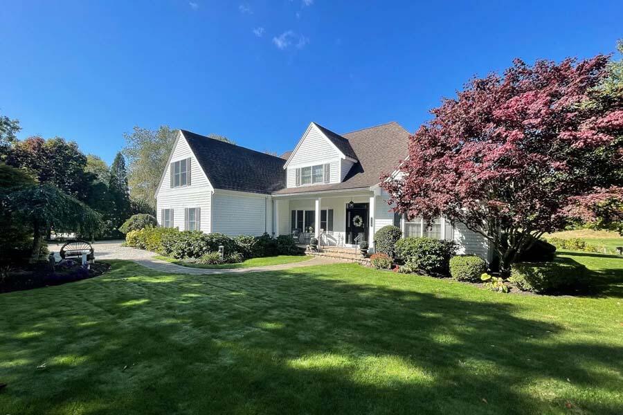 310 Willowbend Drive Mashpee, MA 02649 - Photo 9 of 37 a front view of a house with a garden and trees