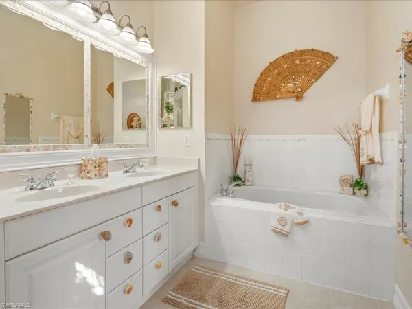 a bathroom with a tub sink and mirror