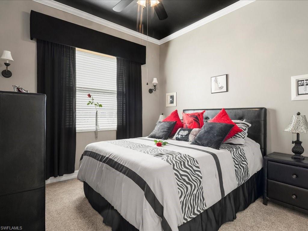 7918 Haven Drive, Unit 2 Naples, FL 34104 - Photo 25 of 30 a bedroom with a bed and a chandelier