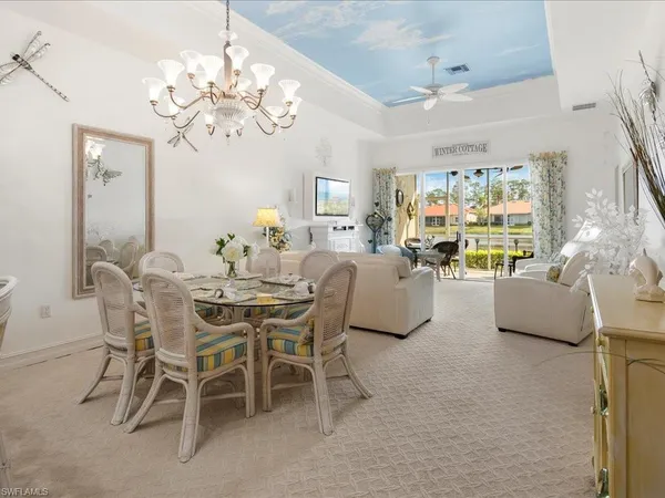 a view of a dining room with furniture a chandelier and a flat screen tv