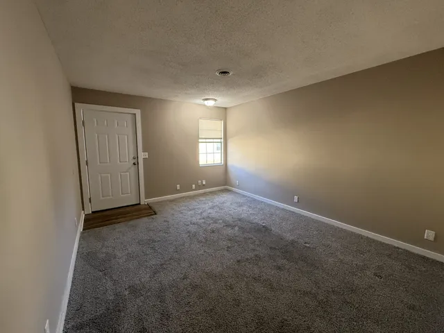 an empty room with windows and closet in it