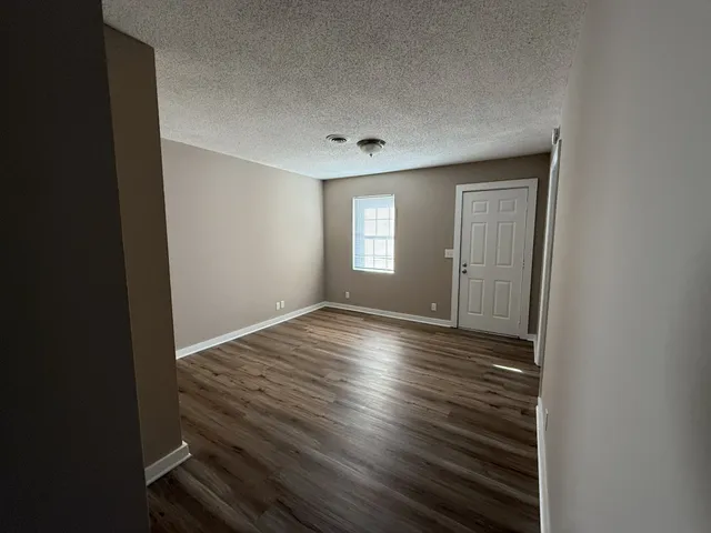 a view of a room with wooden floor and window