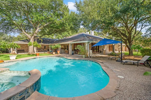 a view of a house with swimming pool and sitting area