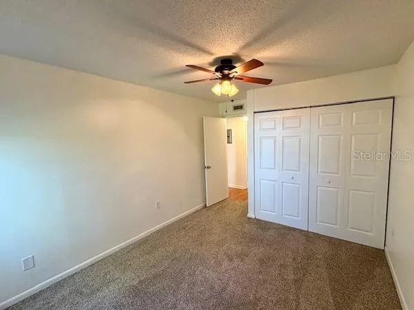 an empty room with a chandelier fan and a ceiling fan