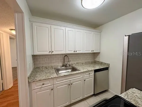 a kitchen with stainless steel appliances granite countertop a sink and cabinets