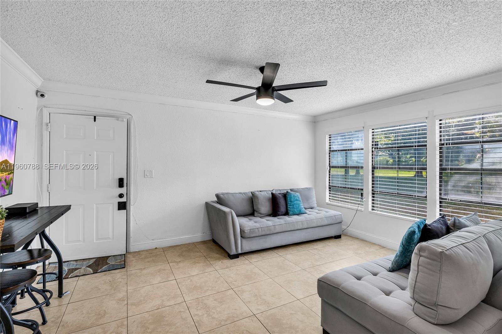 15680 Southwest 106th Lane, Unit 815 Miami, FL 33196 - Photo 11 of 32 a living room with furniture and a window