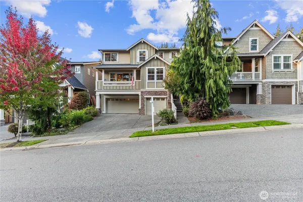 a front view of a house with a yard and potted plants