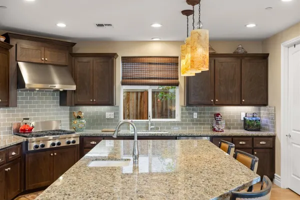 a kitchen with kitchen island granite countertop a sink cabinets and window