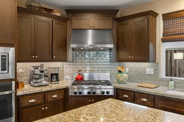 a kitchen with stainless steel appliances granite countertop a sink stove and cabinets