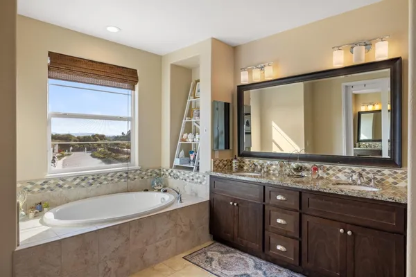 a bathroom with a bathtub sink and mirror