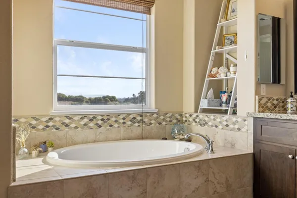 a bathroom with bathtub and a window